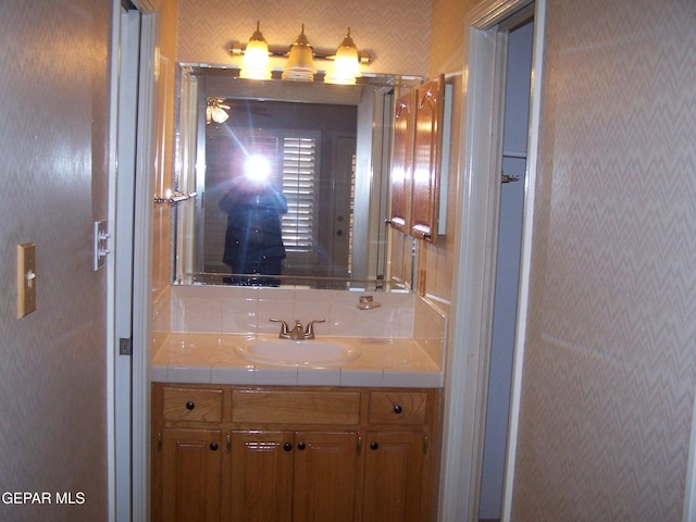 bathroom featuring vanity and decorative backsplash