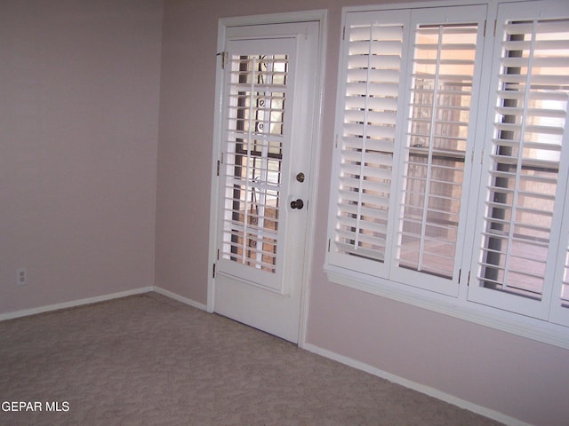 entryway with baseboards and carpet floors