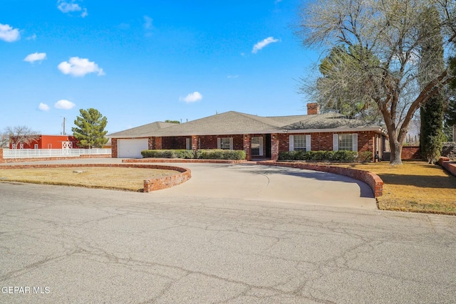 ranch-style home with driveway, brick siding, a front lawn, and an attached garage