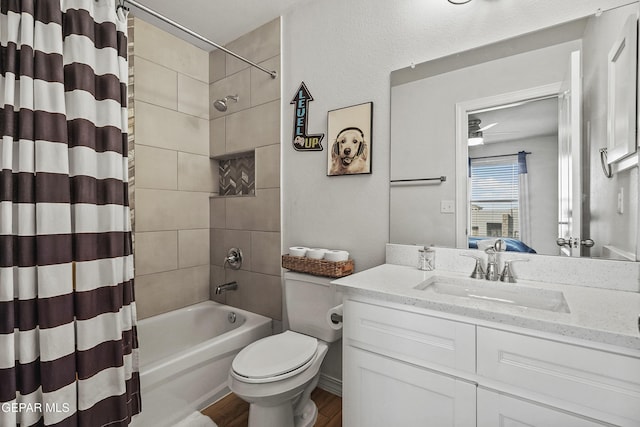 bathroom featuring shower / bathtub combination with curtain, toilet, ceiling fan, vanity, and wood finished floors