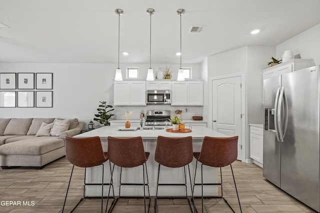 kitchen with light countertops, visible vents, decorative backsplash, appliances with stainless steel finishes, and wood tiled floor