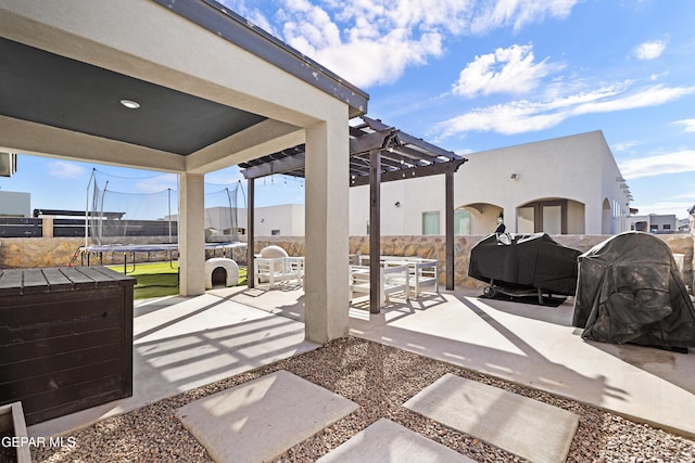 view of patio / terrace featuring a trampoline, grilling area, outdoor dining space, fence, and a pergola