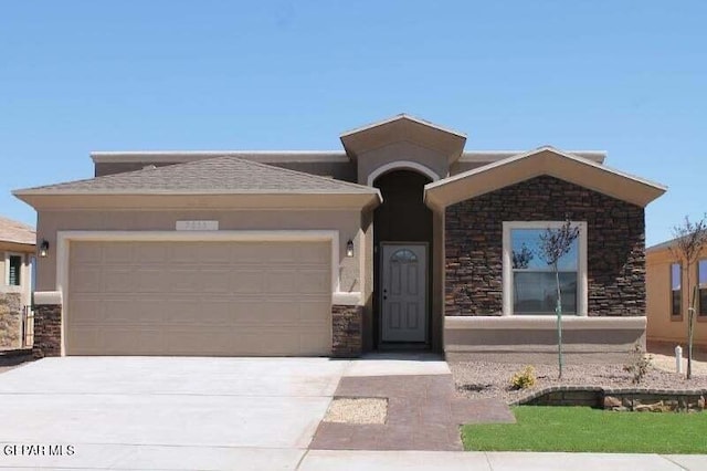 view of front of house with a garage, stone siding, driveway, and stucco siding