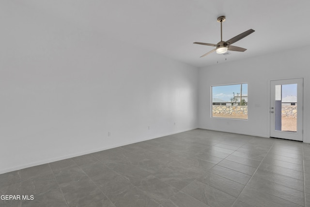 empty room featuring a ceiling fan and baseboards