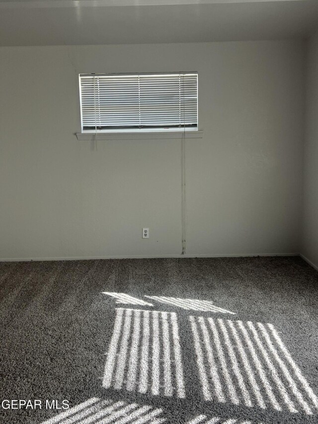 carpeted spare room featuring baseboards