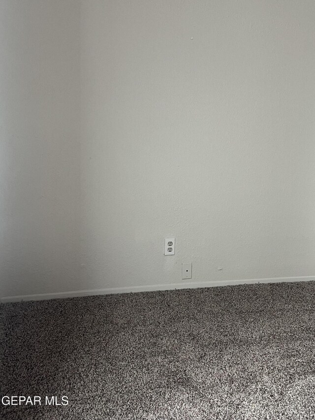 carpeted spare room featuring baseboards