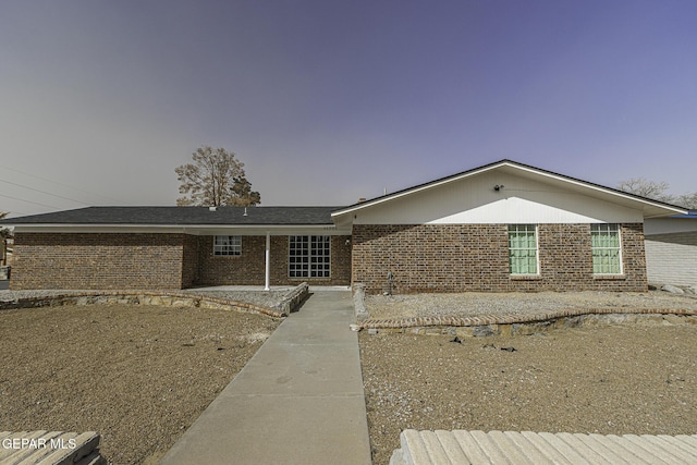 ranch-style home featuring brick siding and a patio area