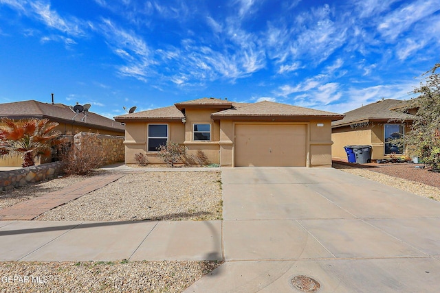 view of front of home with a garage, concrete driveway, a tiled roof, and stucco siding