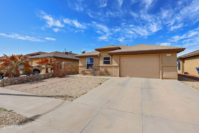 prairie-style home with a garage, driveway, and stucco siding