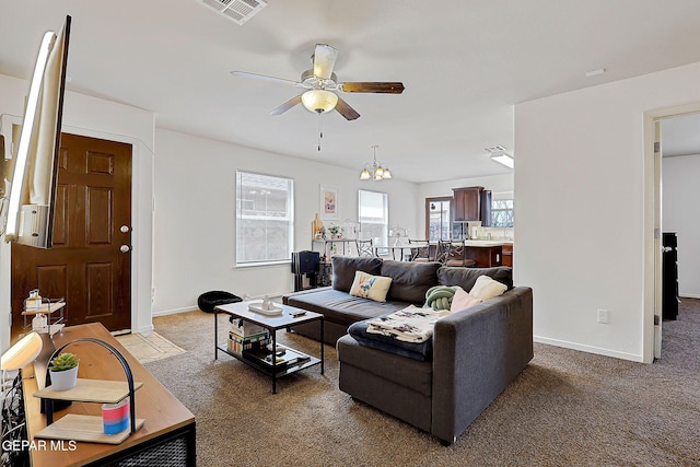 living room featuring ceiling fan, baseboards, visible vents, and light colored carpet