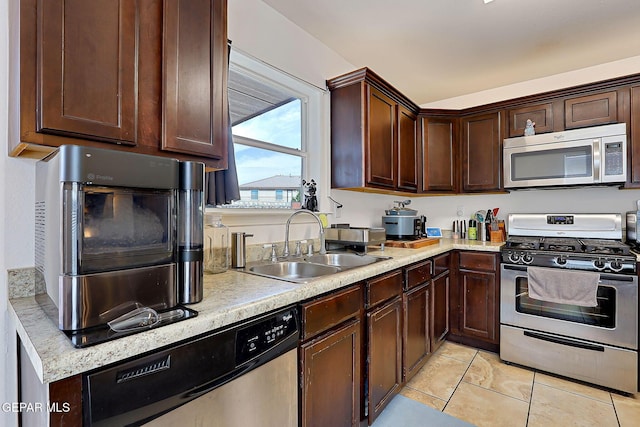 kitchen with appliances with stainless steel finishes, light countertops, and a sink