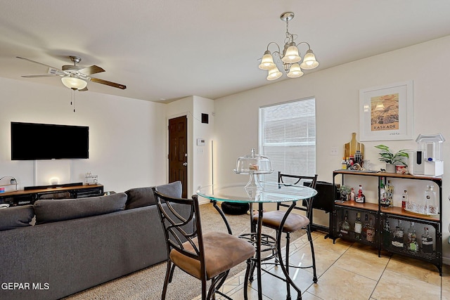 dining space with light tile patterned floors, baseboards, and ceiling fan with notable chandelier