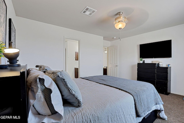 carpeted bedroom with visible vents, baseboards, and ensuite bathroom