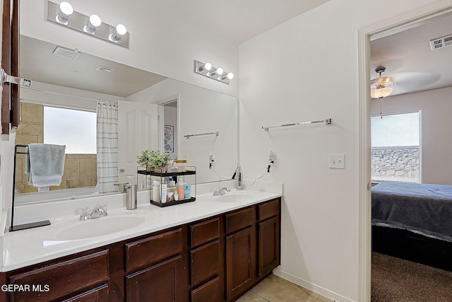 ensuite bathroom with double vanity, a sink, visible vents, and connected bathroom