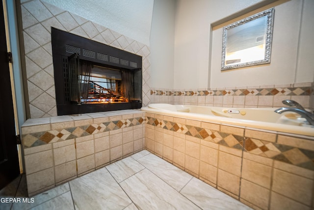 full bath featuring a garden tub and a tile fireplace