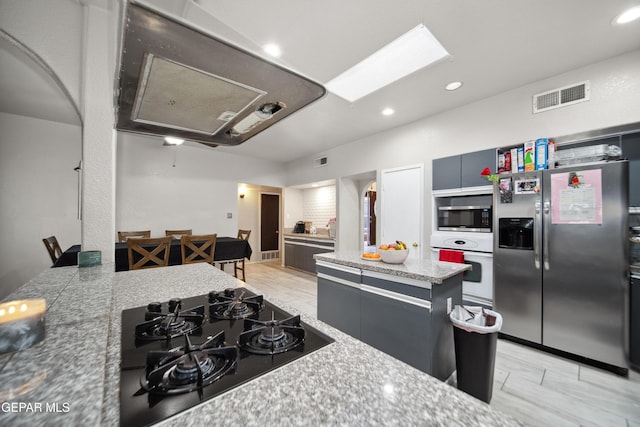 kitchen featuring recessed lighting, visible vents, stainless steel appliances, and a center island