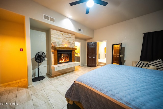 bedroom with a glass covered fireplace, visible vents, and baseboards