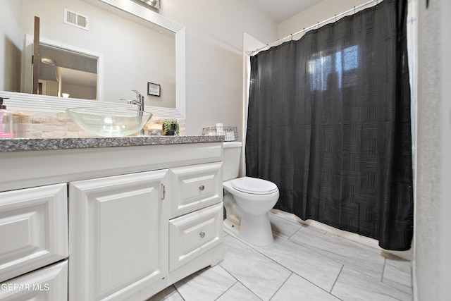 bathroom featuring toilet, visible vents, a shower with shower curtain, and vanity