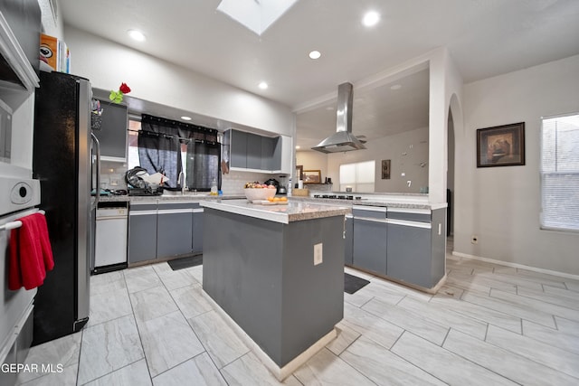 kitchen featuring a center island, gray cabinets, light countertops, and island range hood