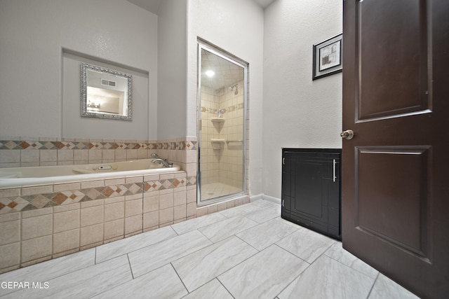 bathroom featuring a stall shower and a garden tub