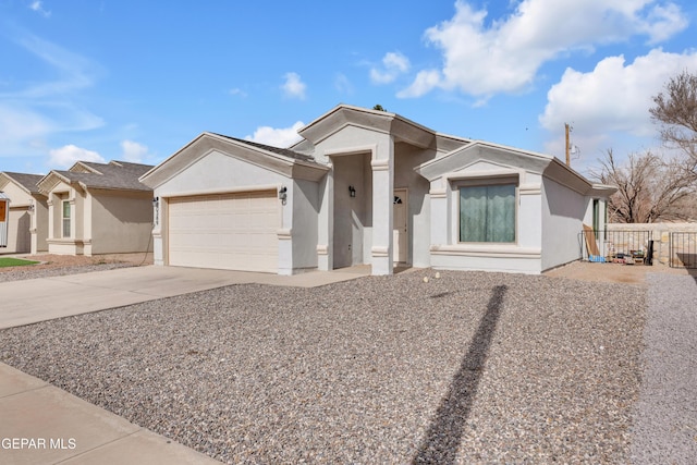 view of front facade featuring an attached garage, driveway, fence, and stucco siding