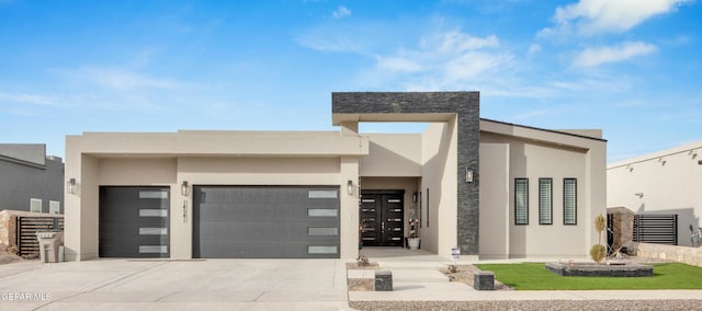 modern home featuring a garage, concrete driveway, and stucco siding