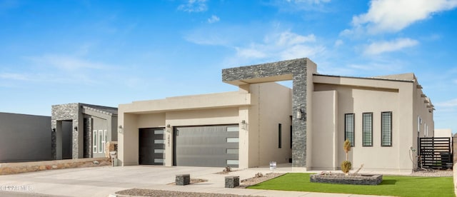 contemporary house featuring a garage, concrete driveway, and stucco siding