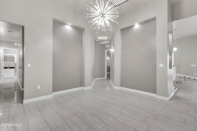 interior space featuring a chandelier, wood finish floors, and baseboards