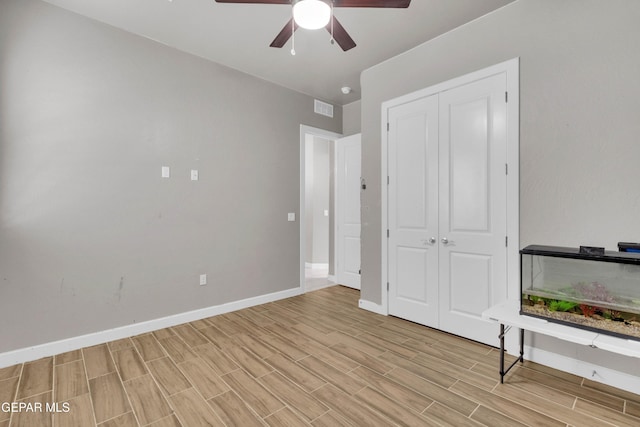 unfurnished bedroom with a ceiling fan, baseboards, visible vents, a closet, and wood tiled floor