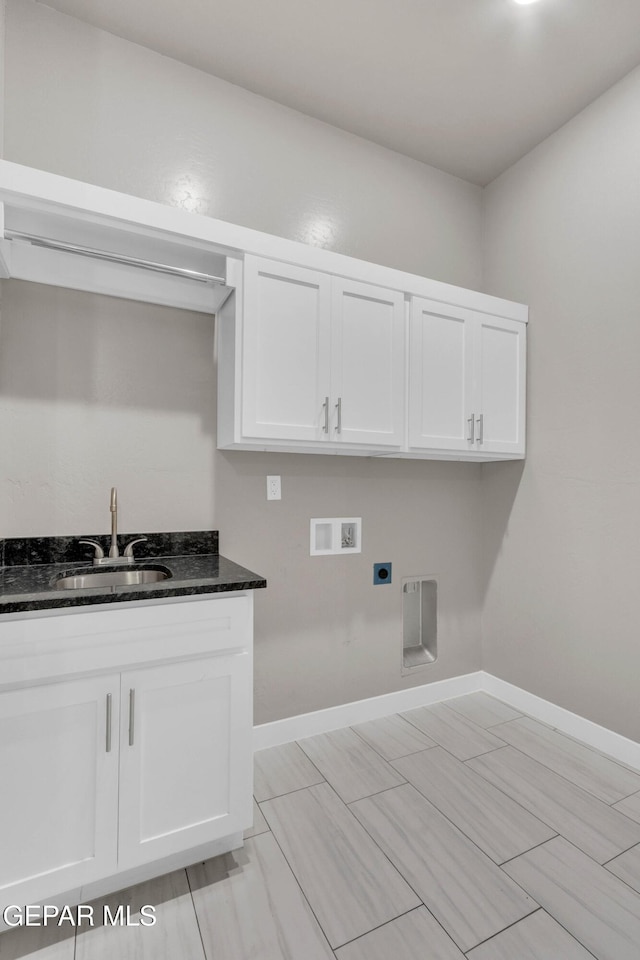 washroom with baseboards, hookup for an electric dryer, a sink, and hookup for a washing machine