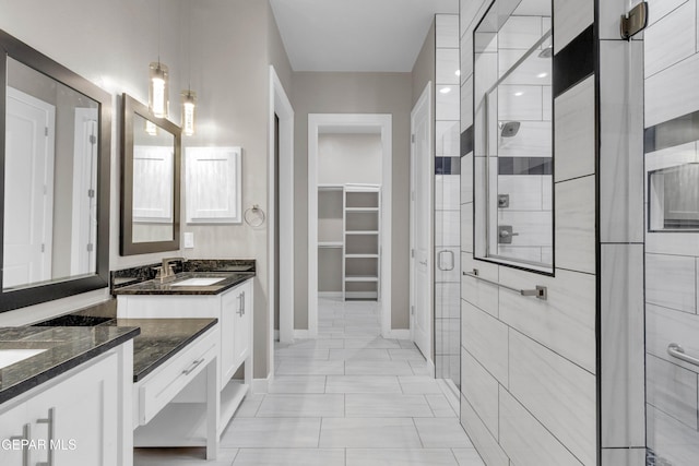 bathroom with baseboards, a shower stall, vanity, and a spacious closet