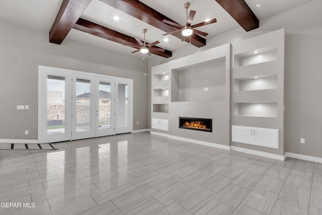 unfurnished living room featuring built in shelves, a warm lit fireplace, and baseboards