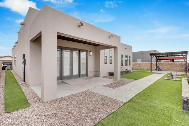 back of property featuring a yard, stucco siding, a patio, and a pergola