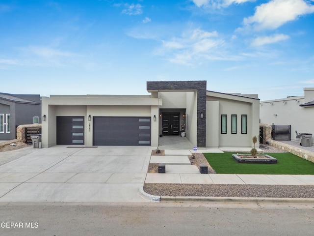 modern home with a garage, driveway, and stucco siding