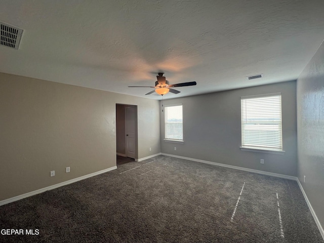 carpeted empty room with a textured ceiling, ceiling fan, visible vents, and baseboards