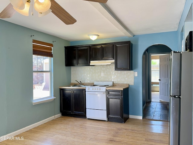 kitchen featuring a wealth of natural light, white range with electric stovetop, under cabinet range hood, and freestanding refrigerator