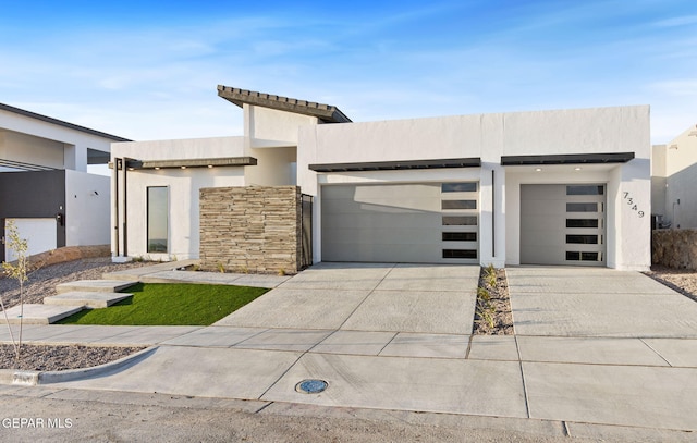 modern home featuring driveway, an attached garage, and stucco siding