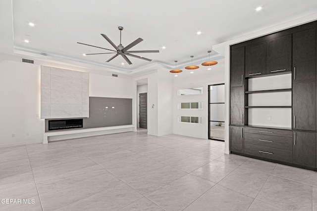 unfurnished living room with visible vents, ceiling fan, a tray ceiling, a fireplace, and recessed lighting