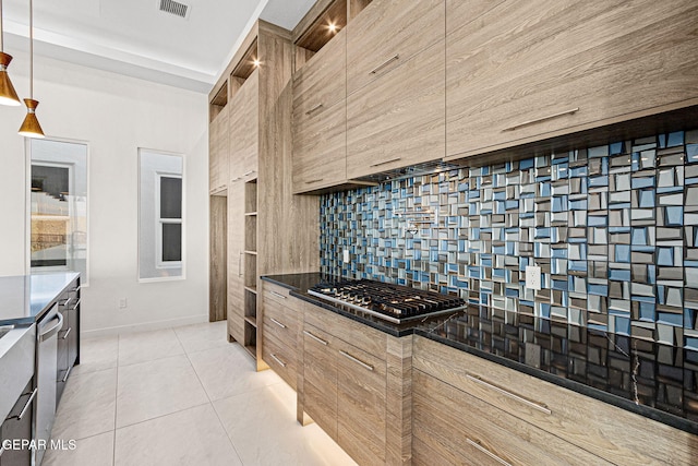 kitchen featuring light tile patterned floors, stainless steel appliances, dark countertops, backsplash, and modern cabinets