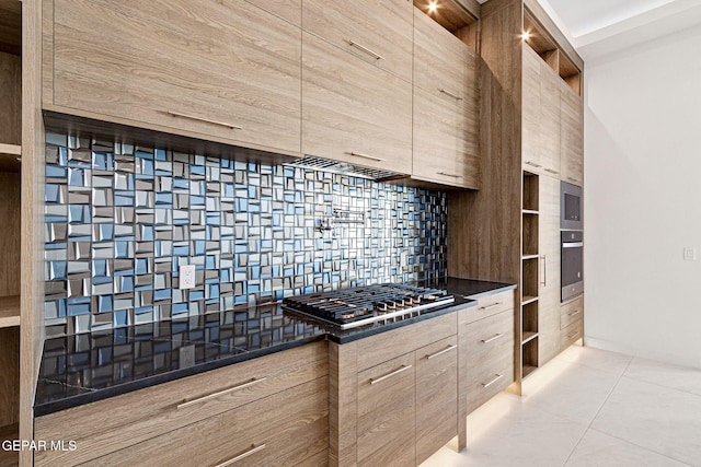 kitchen with light brown cabinets, tasteful backsplash, dark countertops, modern cabinets, and stainless steel gas stovetop