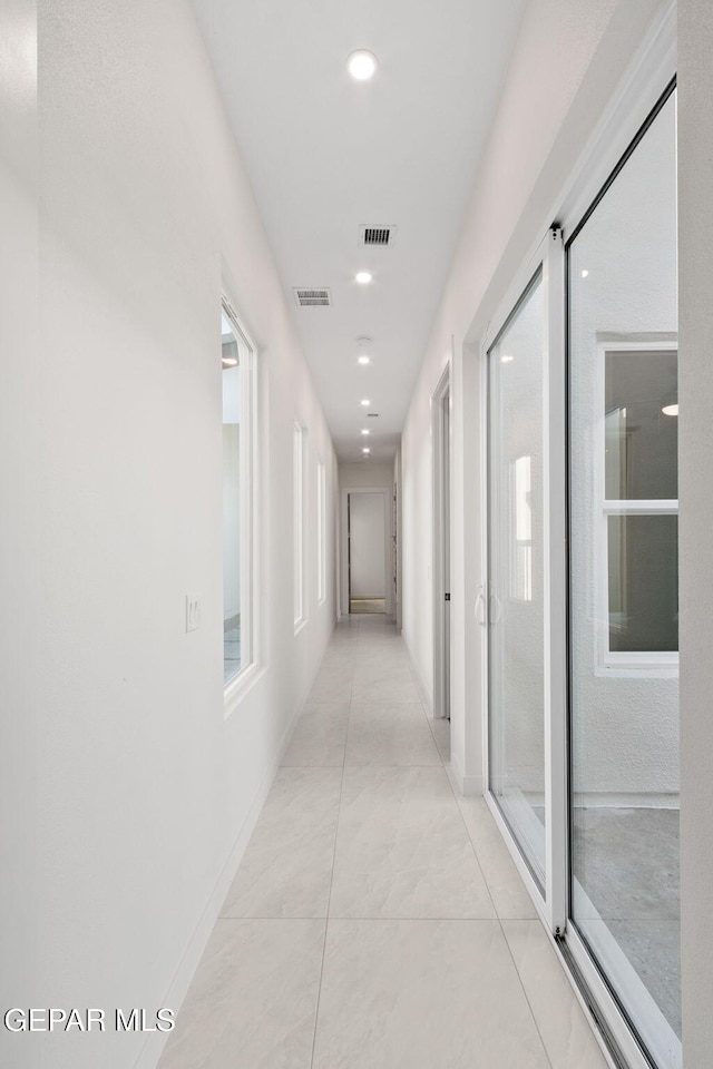 hallway featuring recessed lighting, visible vents, and light tile patterned floors