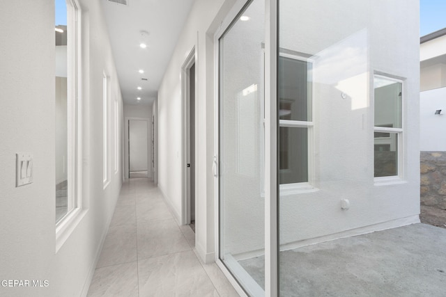 hall featuring baseboards and recessed lighting