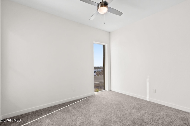 spare room featuring carpet floors, a ceiling fan, and baseboards