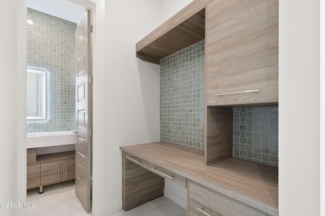 mudroom with light tile patterned floors and tile walls