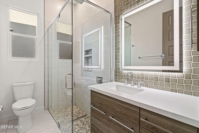 bathroom with tile patterned flooring, toilet, vanity, backsplash, and a stall shower