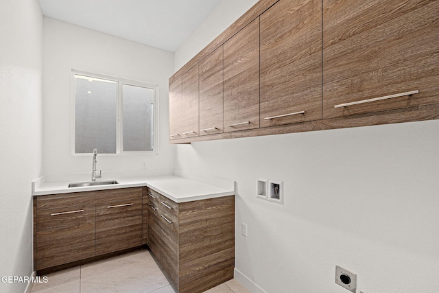 clothes washing area with a sink, cabinet space, hookup for a washing machine, and hookup for an electric dryer