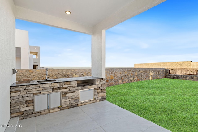 view of patio / terrace featuring an outdoor kitchen and a sink