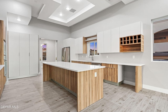 kitchen with a center island, visible vents, appliances with stainless steel finishes, light wood-style floors, and modern cabinets