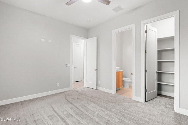 unfurnished bedroom with carpet floors, baseboards, a spacious closet, and visible vents