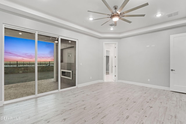 spare room featuring ceiling fan, wood finished floors, visible vents, and baseboards
